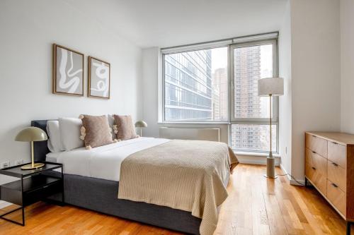 a bedroom with a large bed and two windows at Blueground Hells Kitchen gym wd nr museum NYC-1433 in New York