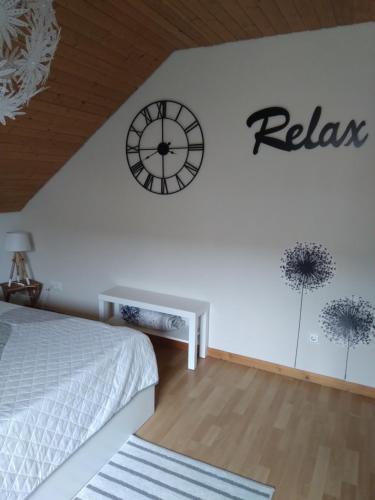 1 dormitorio con reloj en la pared en Ferienwohnung Monteurwohnung Pusteblume, en Duderstadt