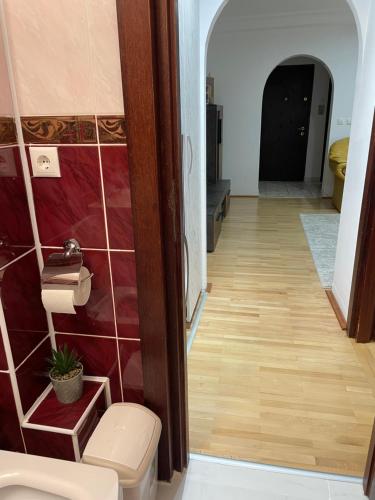 a hallway with a toilet in a room with red tiles at Central Cozy Apartament Near Monastery in Suceava