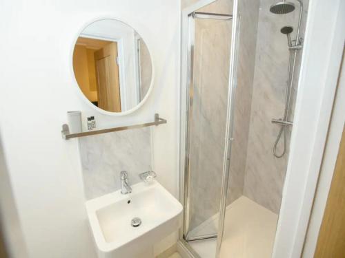 a bathroom with a shower and a sink and a mirror at Pass the Keys The Sunny Room at Tavmar Apartments in Lincoln