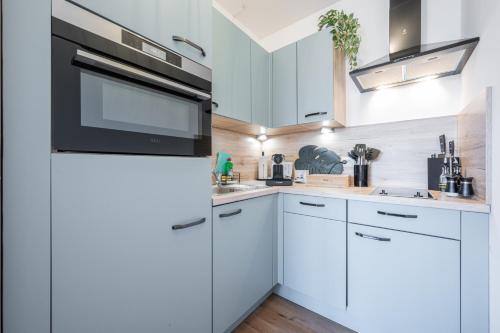 a kitchen with white cabinets and a refrigerator at Modernes Apartment Wels City Center in Wels