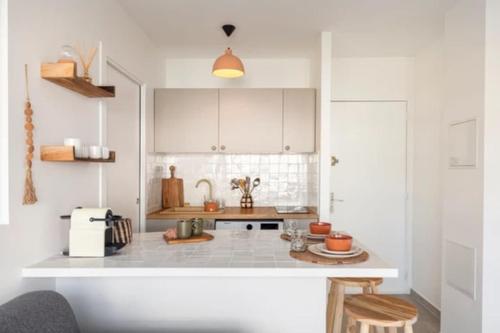 une cuisine avec des armoires blanches et un comptoir dans l'établissement Appartement Cannes 1 chambre - QG, à Cannes