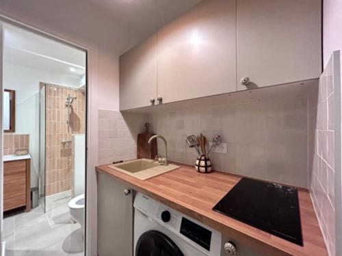 une cuisine avec un évier et une machine à laver dans l'établissement Appartement Cannes 1 chambre - QG, à Cannes