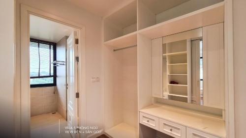 a bathroom with white cabinets and a walk in shower at Phoenix Villas FLC Ha Long in Ha Long