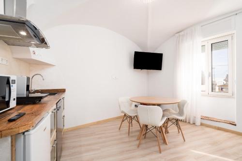 a kitchen with a table and chairs in a room at Giojas125- Monolocale per 2 persone in Orosei