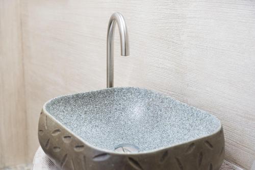 a metal sink with a faucet in a bathroom at Giojas125- Monolocale per 2 persone in Orosei