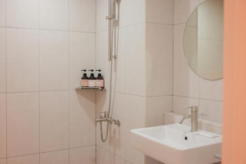 y baño blanco con lavabo y ducha. en Ace Hotel by Cozy Daejeon Yuseong Branch, en Daejeon