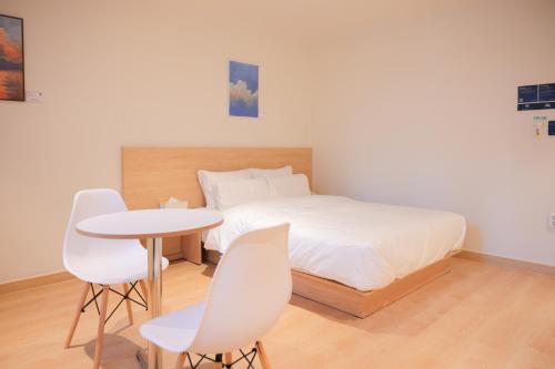 1 dormitorio con 1 cama, mesa y sillas en From H Ace Hotel Daejeon by Aank en Daejeon