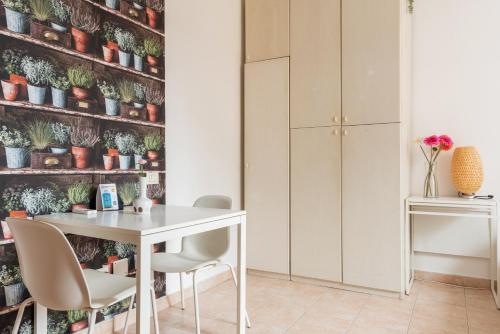 tavolo e sedie in una stanza con piante su una parete di Monolocale Sarpi a Milano