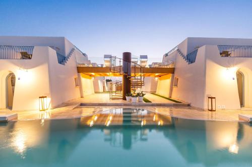 a swimming pool in front of a house at La Corte Relais in Torre Pali 