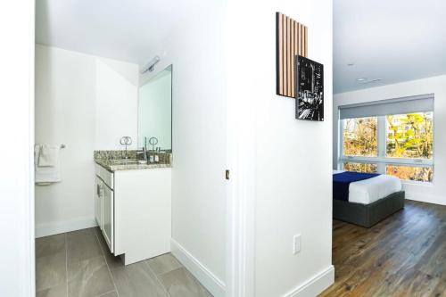 ein Bad mit einem Waschbecken und ein Bett in einem Zimmer in der Unterkunft Luxury Apartment w Office & Gym in Peabody