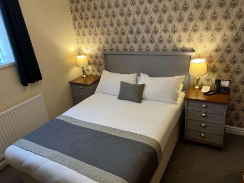 a bedroom with a bed with two night stands and two lamps at Best Western Valley Hotel in Ironbridge