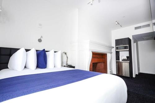 ボストンにあるStylish Hotel Room in Boston's Fenway - Unit #107のベッドルーム1室(大型ベッド1台、青と白の枕付)