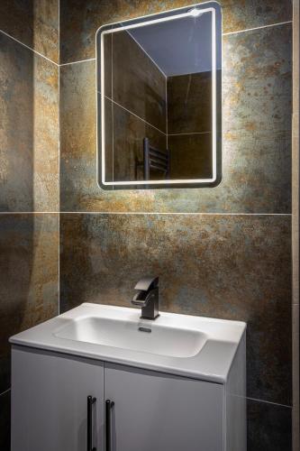 a bathroom with a white sink and a mirror at The Charleston in Blackpool