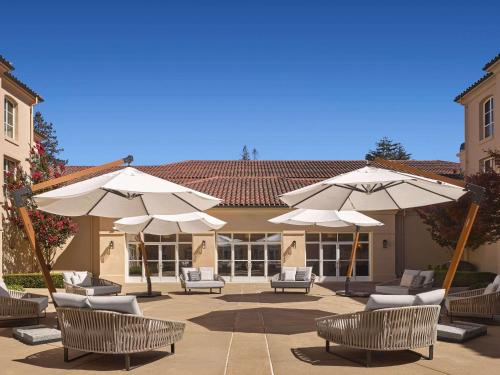 a patio with chairs and umbrellas in front of a building at Hyatt Regency Sonoma Wine Country in Santa Rosa