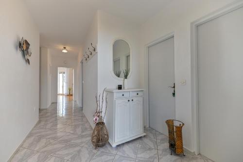 a hallway with a mirror and a vase at Apartments Kapetan in Trogir