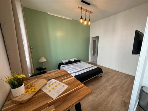 a room with a table and a bed in it at Le Mirabelle in Saintes