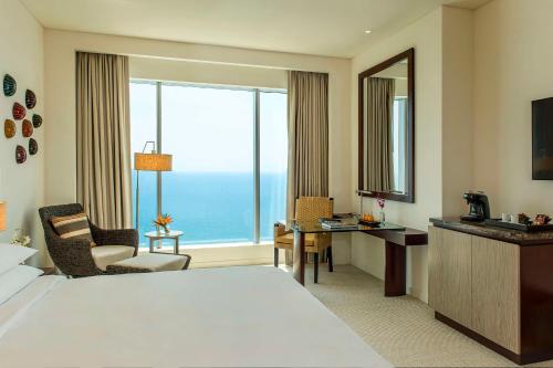 Habitación de hotel con cama, escritorio y ventana grande. en Hyatt Regency Cartagena en Cartagena de Indias