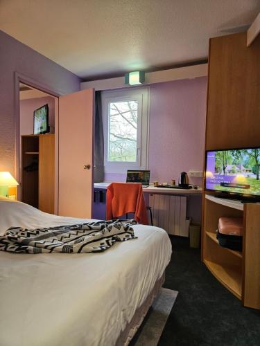 Cette chambre comprend un lit et une télévision à écran plat. dans l'établissement Hotel Bonanite, à Villers-Cotterêts