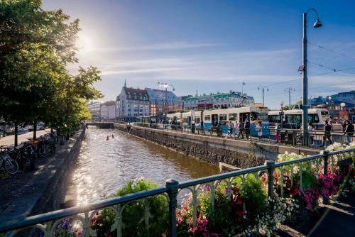 a river in a city with people and flowers at Radisson Blu Scandinavia Hotel, Göteborg in Gothenburg