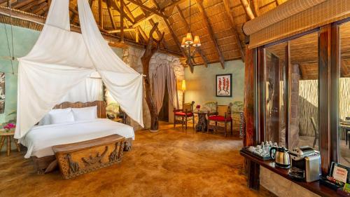 a bedroom with a bed with a mosquito net at Nofa Riyadh, A Radisson Collection Resort in Ţibrāk