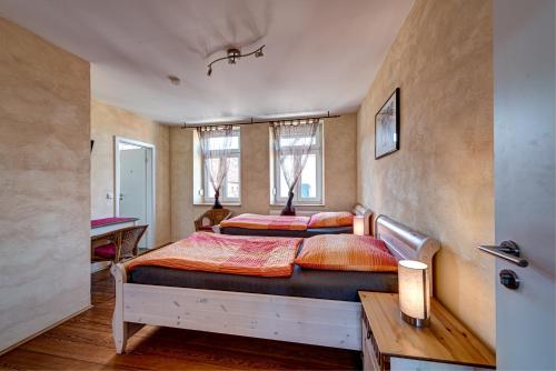 a bedroom with two beds and a desk at Jakobshof in Freckenfeld