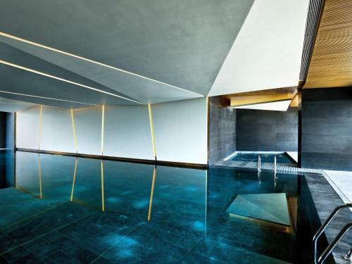 een kamer met een zwembad met een tafel en stoelen bij East Beijing in Beijing