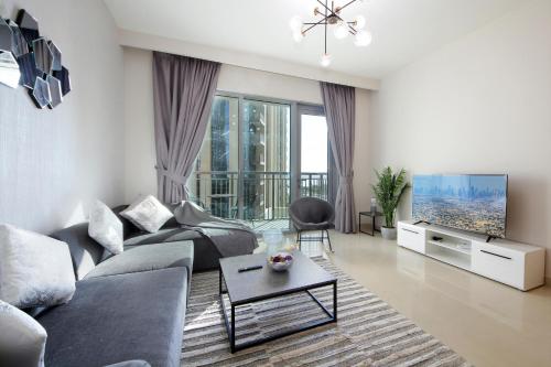 a living room with a couch and a tv at Elegant Waterfront 1BHK in Dubai Creek Harbour in Dubai