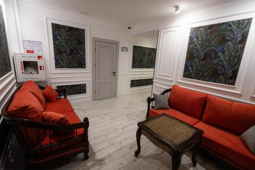 a living room with a couch and a chair at Metelitsa Hotel in Karagandy