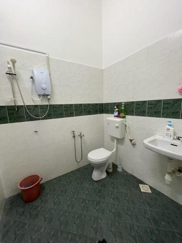 y baño con aseo y lavamanos. en My Delima Home for MusIim, en Keluang