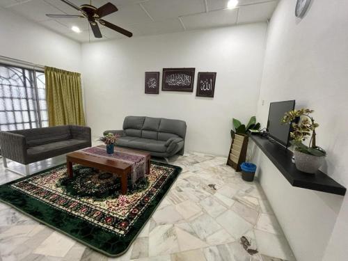 uma sala de estar com um sofá e uma mesa em My Delima Home for MusIim em Keluang