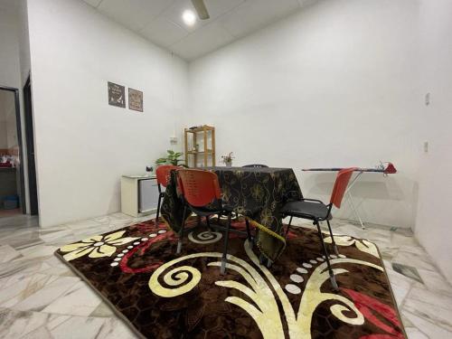a room with two chairs and a table and a rug at My Delima Home for MusIim in Kluang