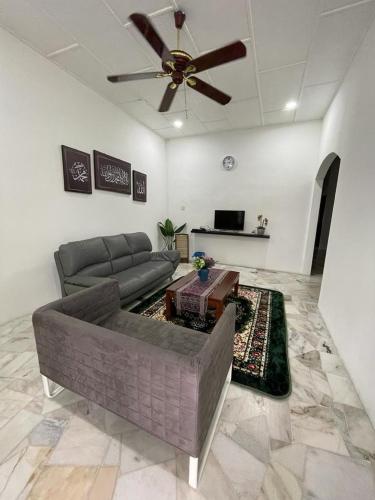 uma sala de estar com um sofá e uma ventoinha de tecto em My Delima Home for MusIim em Keluang