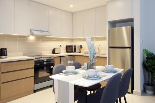 a kitchen with a table with chairs and a refrigerator at Elegant Waterfront 1BHK in Dubai Creek Harbour in Dubai