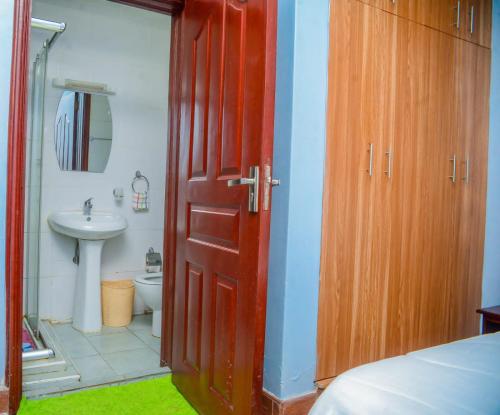 a bathroom with a red door and a sink at Kothuondo's 2 &3edrooms all ensuite apartment in Kisumu