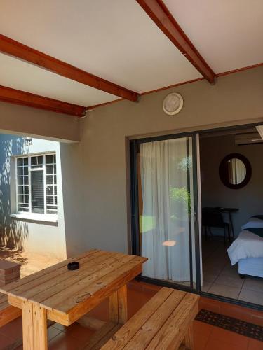 a room with a wooden bench and a table at UNIQUE BnB in Vryheid