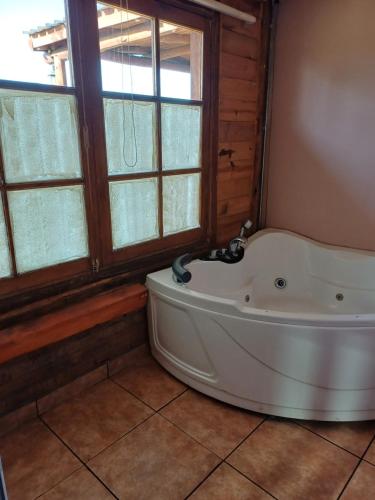 eine Badewanne in einem Zimmer mit Fenster in der Unterkunft Cabañas Los Piamonteses Cosmopolita in Juan L. Lacaze