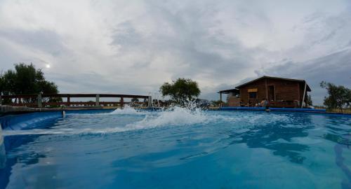 una gran piscina con una casa en el fondo en Cabañas Los Piamonteses Cosmopolita en Juan L. Lacaze