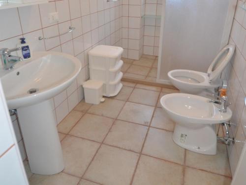 Baño blanco con lavabo y aseo en Casa Milo, en Torre Vado
