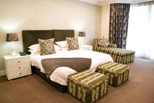 - une chambre avec un grand lit et 2 ottomanes dans l'établissement 10 2ND AVENUE HOUGHTON ESTATE BOUTIQUE HOTEL, à Johannesbourg