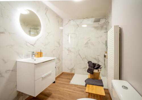 La salle de bains blanche est pourvue d'un lavabo et d'un miroir. dans l'établissement Maison cosy et chaleureuse, à Marly