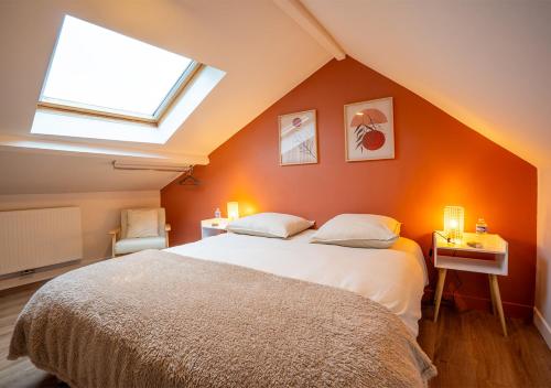 a bedroom with a large bed with an orange wall at Maison cosy et chaleureuse in Marly