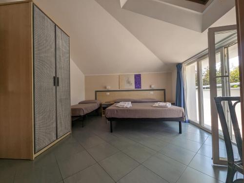 sypialnia z 2 łóżkami i dużym oknem w obiekcie Hotel Doria w mieście Bellaria-Igea Marina