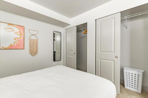 a bedroom with a white bed and a closet at Blueground Bellevue coffee bar nr transport SEA-716 in Bellevue