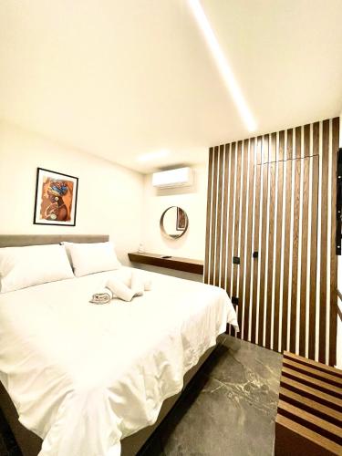a bedroom with a white bed and a window at Modern Home Loft in Alexandroupoli