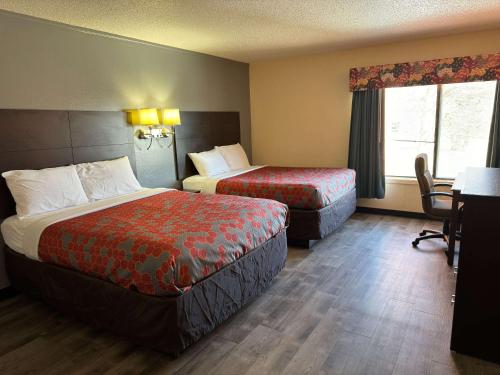 a hotel room with two beds and a desk at Econo Lodge in Waite Park