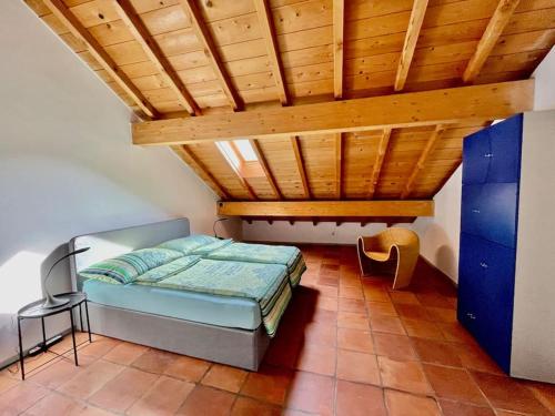 ein Schlafzimmer mit einem Bett und einer Holzdecke in der Unterkunft Grosszügige Dachwohnung in Tessiner Altbau in Monte Ceneri