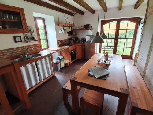une cuisine avec une table en bois et un comptoir en bois dans l'établissement Authentic French house with great view 4 bedrooms and a lot of land, à Troche
