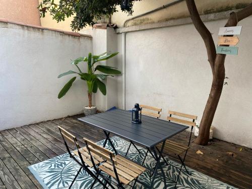 une table noire et des chaises sur une terrasse dans l'établissement La Terrazza, central et confort, à Marseille