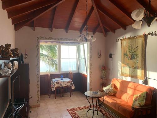 uma sala de estar com um sofá laranja e uma mesa em Apartamento MAR Y TEIDE em Sauzal